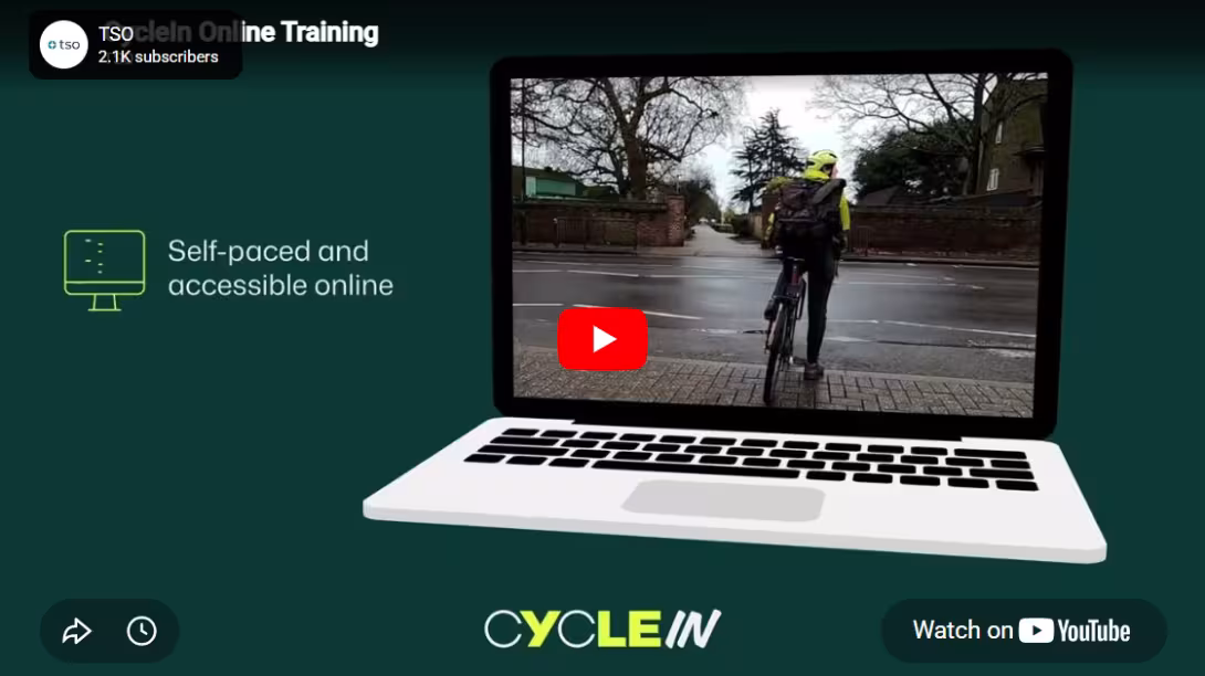 Two adults cycling along a protected cycle lane, shown as a preview of the CycleIn training video.